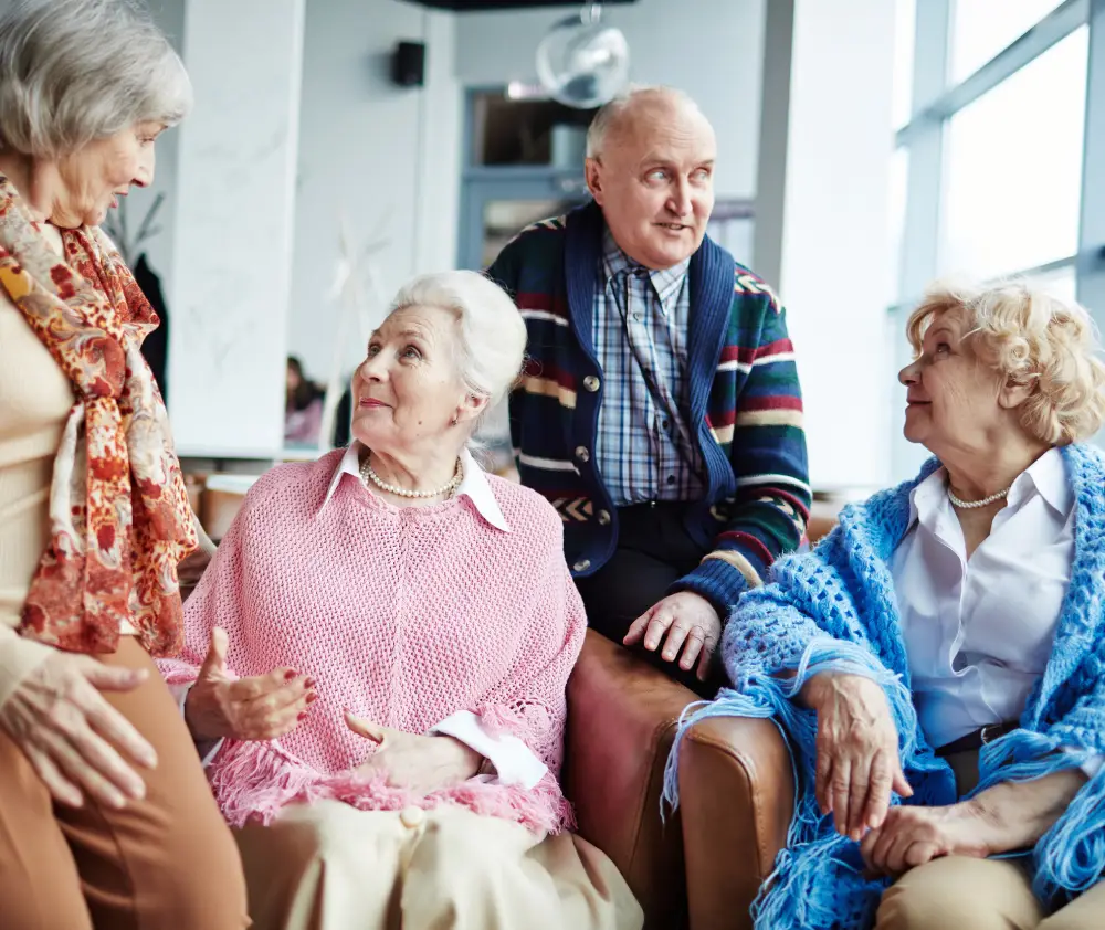 Aged-adults-having-conversation-indoors-1 Old couple, portrait and helping man in wheelchair, home and support husband with injury